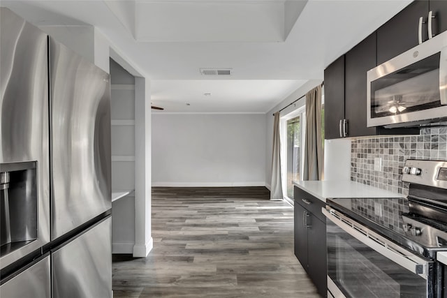 kitchen featuring appliances with stainless steel finishes, backsplash, and dark hardwood / wood-style flooring