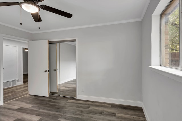 unfurnished bedroom with multiple windows, dark hardwood / wood-style flooring, ceiling fan, and a closet