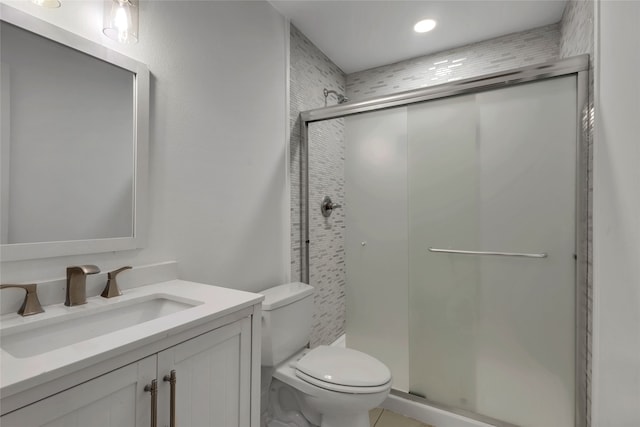 bathroom featuring a shower with shower door, toilet, and vanity