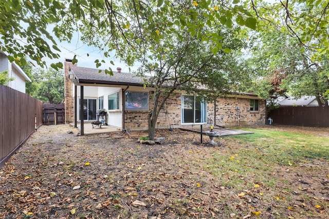 back of house featuring a patio area and a yard