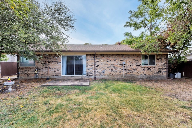 back of property with a lawn and a patio