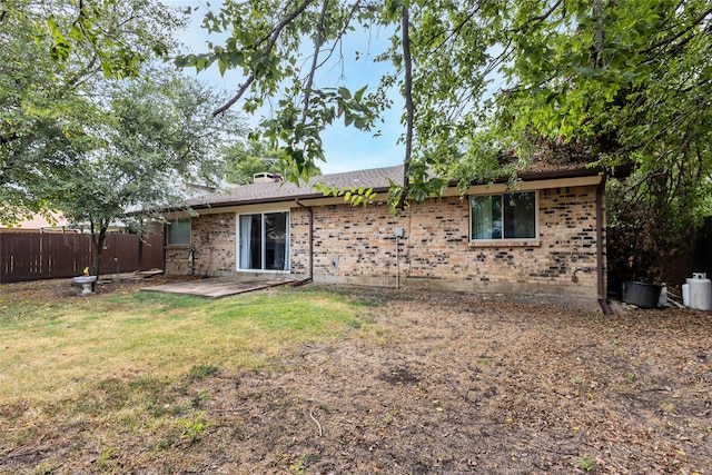 back of property with a yard and a patio