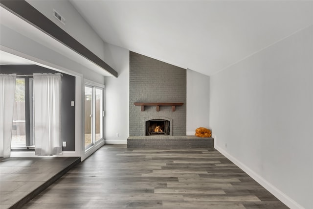 living room with lofted ceiling, hardwood / wood-style floors, and a fireplace