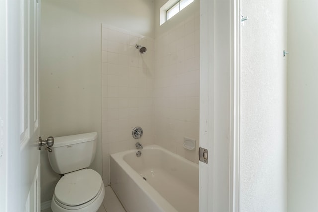 bathroom featuring tiled shower / bath and toilet