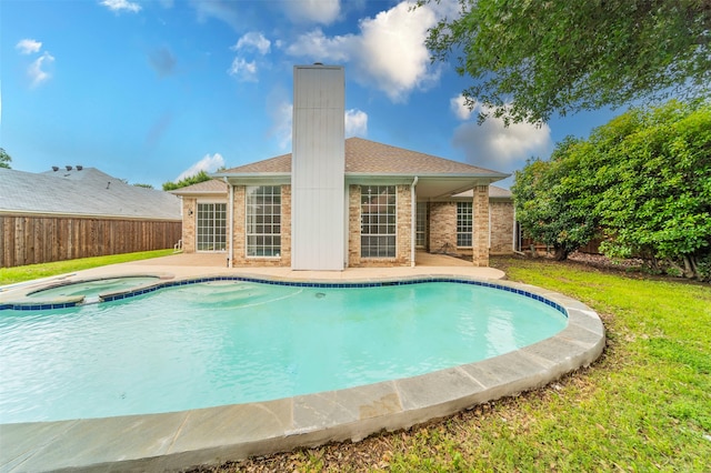 view of pool with a yard, a patio area, and an in ground hot tub