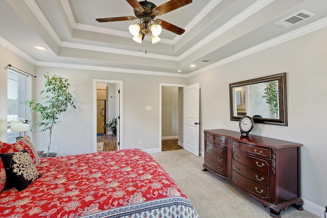 carpeted bedroom featuring a tray ceiling, ceiling fan, and crown molding