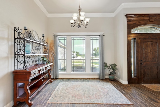 foyer entrance with crown molding, a chandelier, and dark hardwood / wood-style floors