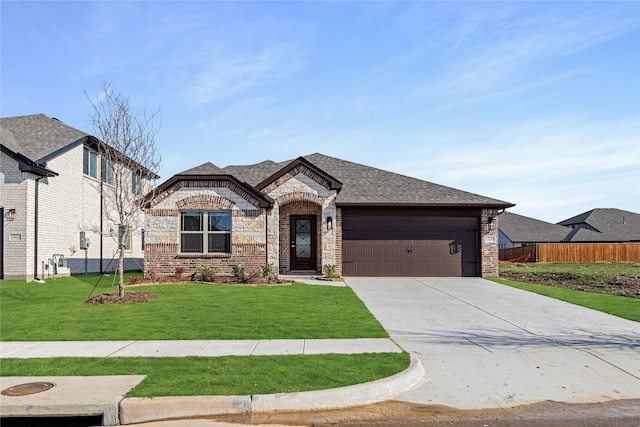 french country inspired facade featuring a garage and a front yard