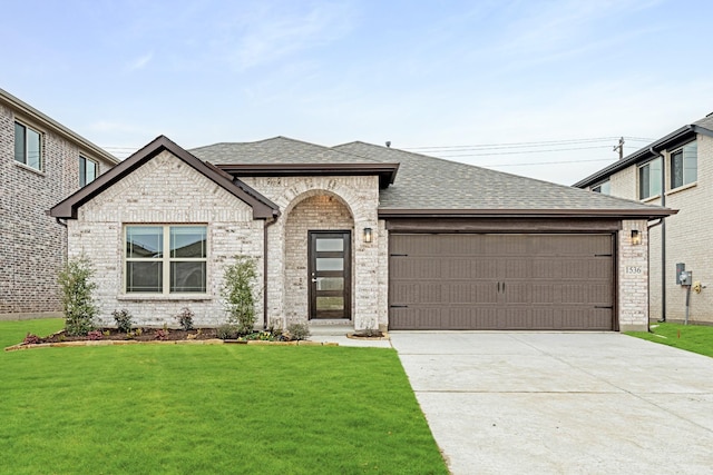 view of front of property with a garage and a front lawn