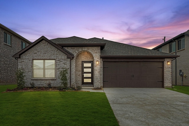 view of front of home with a garage and a yard