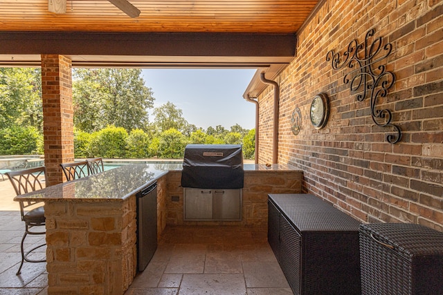 view of patio with exterior bar, area for grilling, and a grill