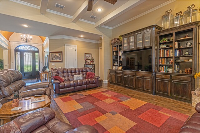 living room with ceiling fan with notable chandelier, hardwood / wood-style flooring, beamed ceiling, and ornamental molding