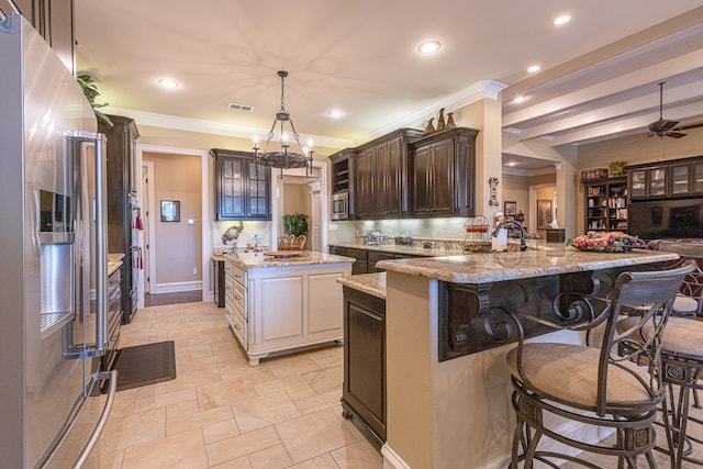 kitchen featuring a center island, light stone countertops, a breakfast bar area, ceiling fan, and stainless steel fridge with ice dispenser