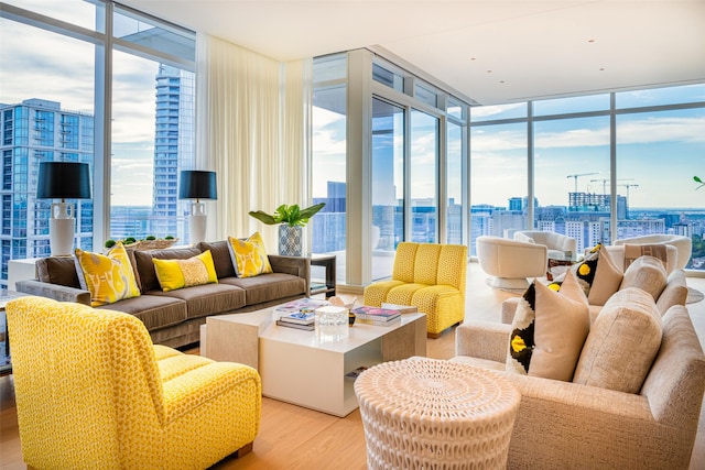 living room featuring light wood-type flooring and floor to ceiling windows