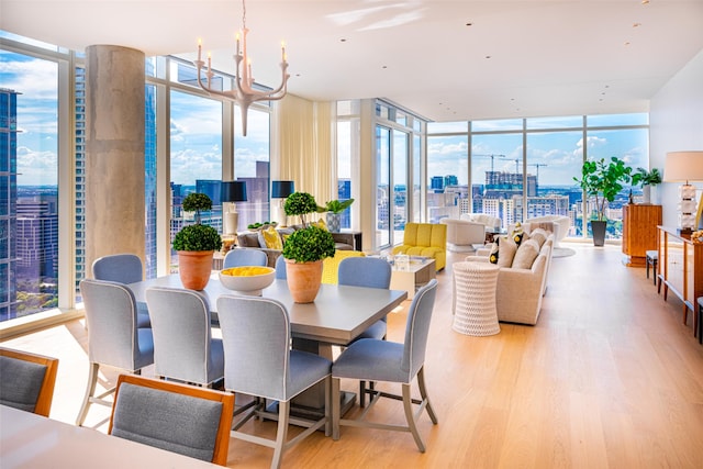 dining space featuring a wall of windows, light hardwood / wood-style floors, and a notable chandelier