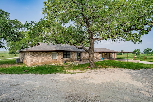 ranch-style home featuring central AC unit and a carport