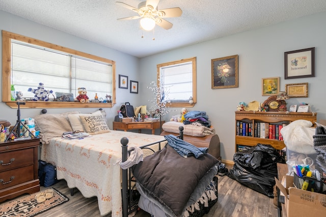 bedroom featuring dark wood-type flooring, ceiling fan, and a textured ceiling