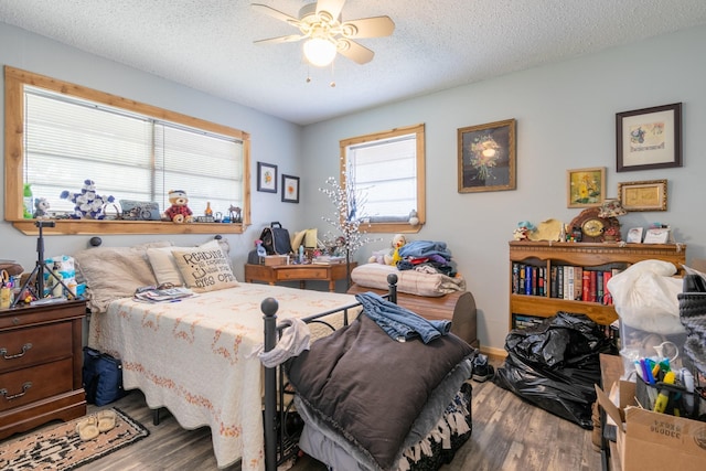 bedroom featuring wood finished floors, a textured ceiling, and ceiling fan