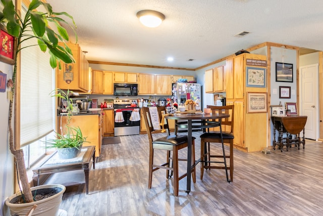 kitchen with a textured ceiling, crown molding, wood-type flooring, and appliances with stainless steel finishes