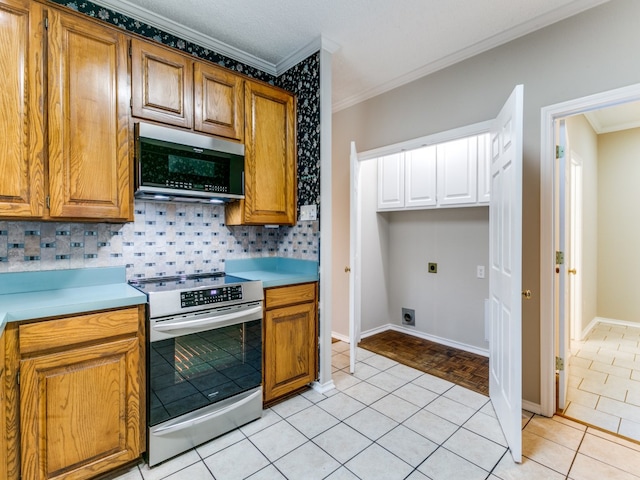 kitchen featuring crown molding, appliances with stainless steel finishes, light tile patterned flooring, and decorative backsplash