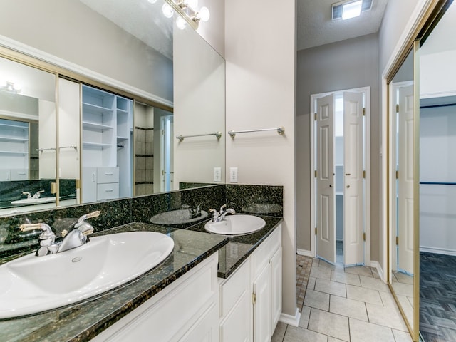 bathroom with vanity, tile patterned floors, and a textured ceiling