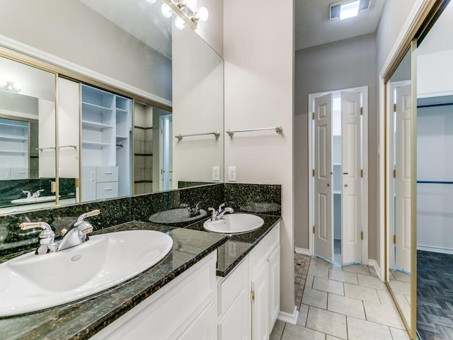 1216 Wooded Trl, Hurst, TX 76053 - full bath with a spacious closet, baseboards, tile patterned floors, and double vanity