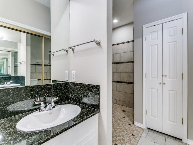 1216 Wooded Trl, Hurst, TX 76053 - bathroom featuring tiled shower, tile patterned floors, vanity, a closet, and baseboards