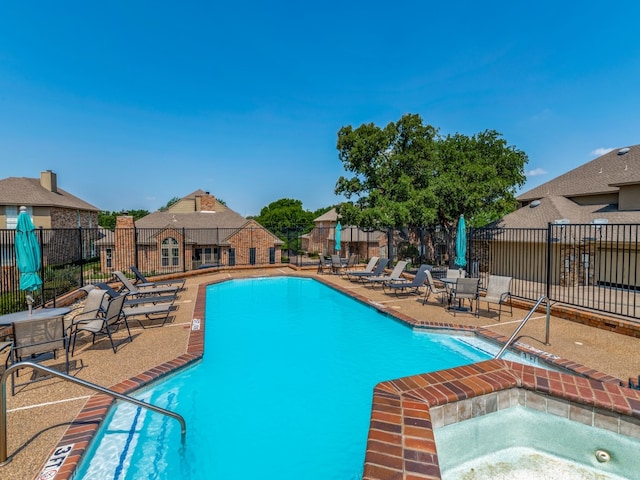 view of pool with a hot tub and a patio