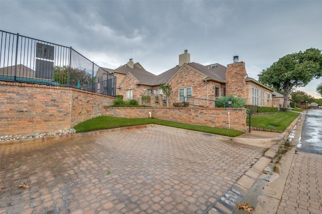 1216 Wooded Trl, Hurst, TX 76053 - view of front facade featuring brick siding, a chimney, and fence