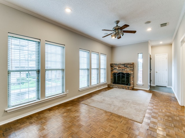 unfurnished living room featuring ornamental molding, a brick fireplace, a textured ceiling, and light parquet floors