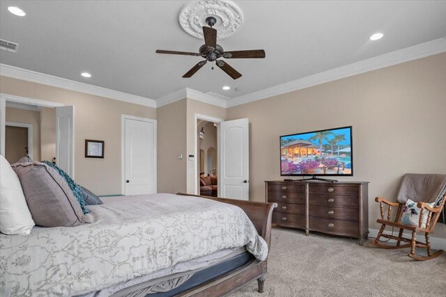 carpeted bedroom featuring ceiling fan and crown molding