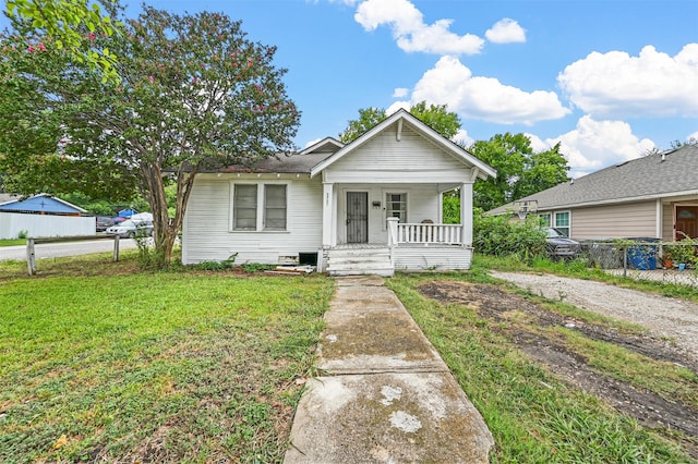 bungalow-style home with covered porch and a front yard