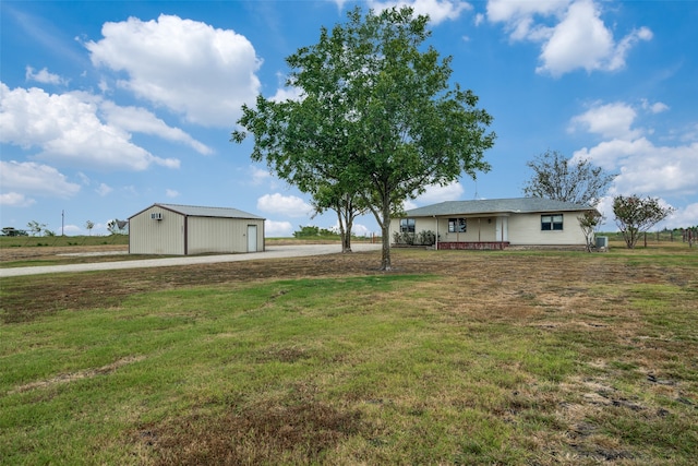 view of yard featuring an outbuilding, a garage, covered porch, and a rural view