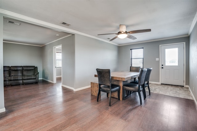 dining space featuring ornamental molding, dark hardwood / wood-style flooring, and a wealth of natural light