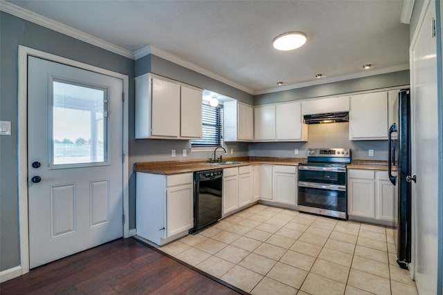 kitchen featuring light wood-type flooring, black appliances, white cabinetry, and a healthy amount of sunlight