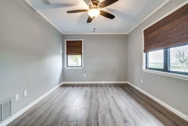 spare room featuring hardwood / wood-style floors, ceiling fan, and crown molding