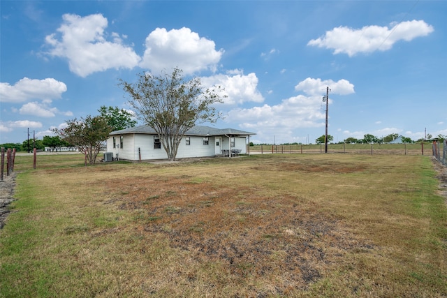 view of yard with central AC unit and a rural view