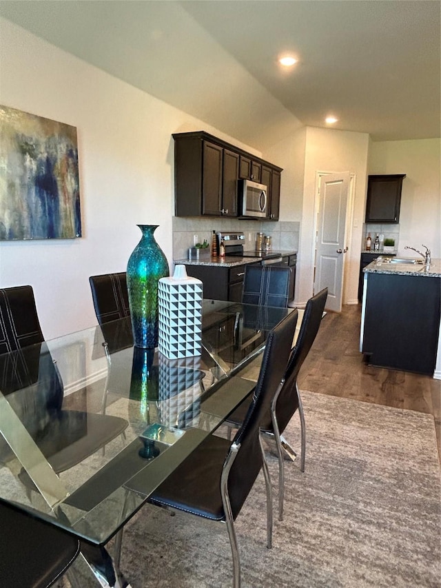 dining space with dark hardwood / wood-style floors and sink