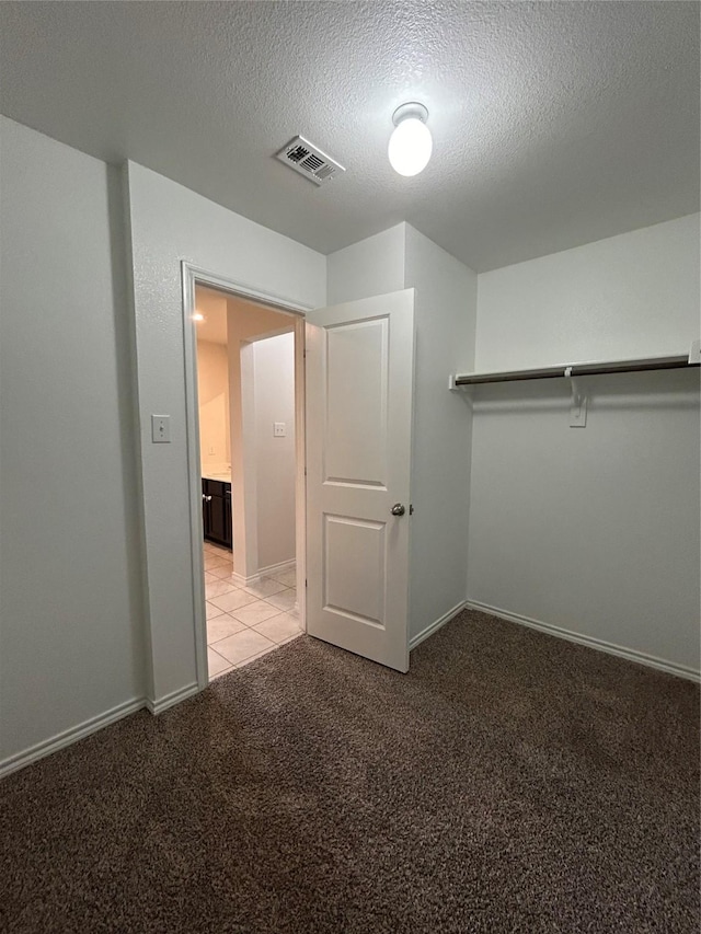 walk in closet with light colored carpet