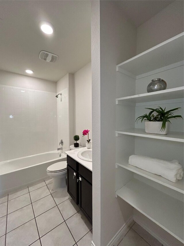 full bathroom with tile patterned floors, vanity, tiled shower / bath combo, and toilet