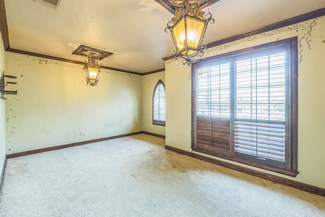 carpeted spare room featuring ornamental molding and a chandelier