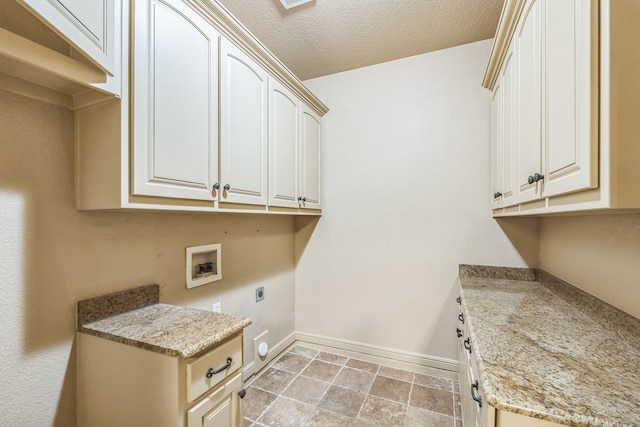 interior space featuring washer hookup, a textured ceiling, cabinets, and electric dryer hookup