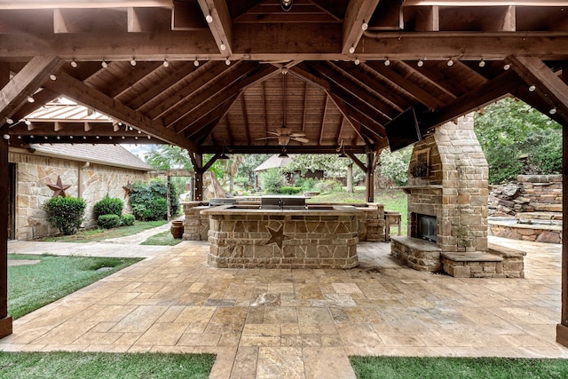 view of patio featuring exterior kitchen, ceiling fan, and a gazebo