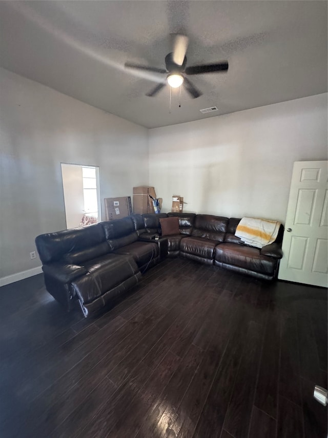 living room featuring ceiling fan, dark hardwood / wood-style flooring, and a textured ceiling