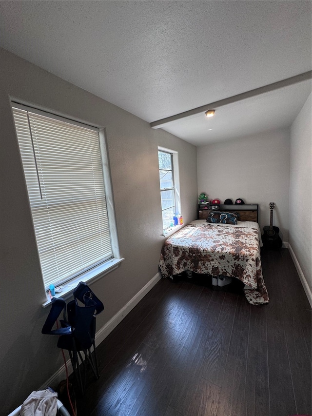 bedroom with dark hardwood / wood-style floors and a textured ceiling