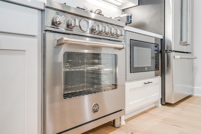 room details featuring appliances with stainless steel finishes and light hardwood / wood-style floors