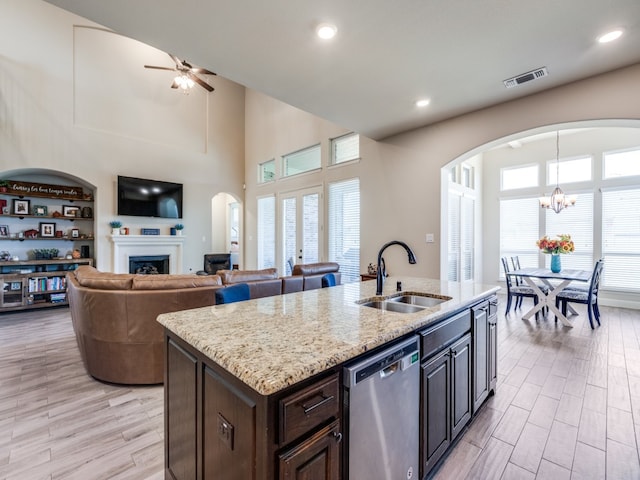 kitchen with sink, dishwasher, a wealth of natural light, and a center island with sink