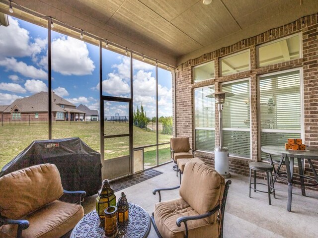 rear view of house featuring a sunroom and a lawn