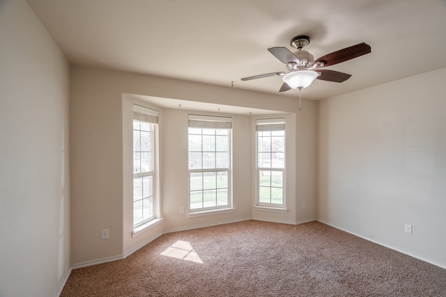 carpeted spare room with ceiling fan