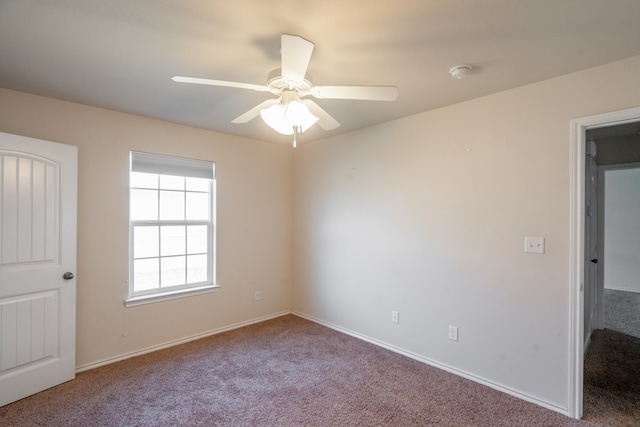 carpeted empty room featuring ceiling fan